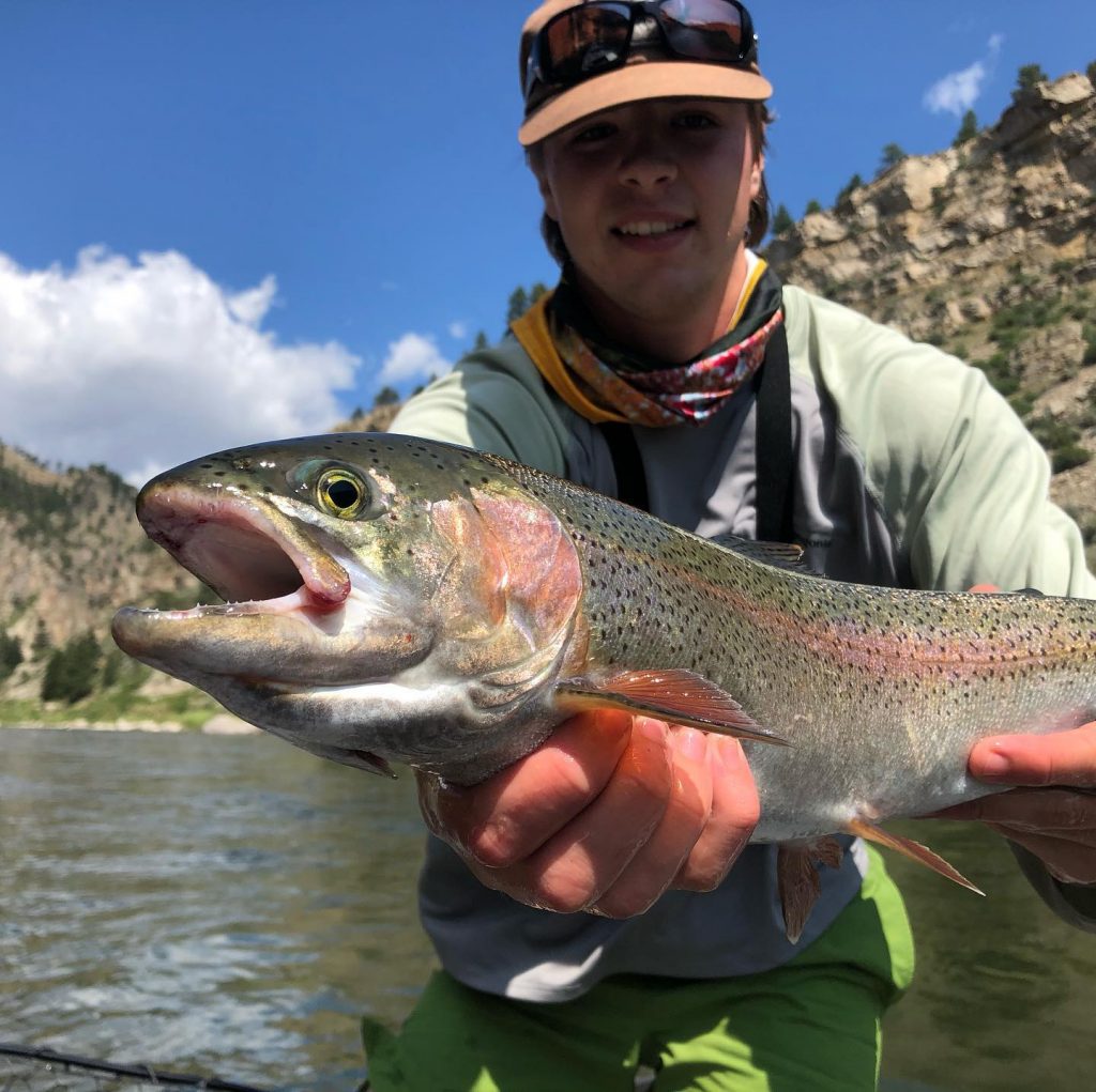 Man holds large trout in river