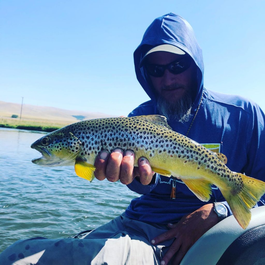 Man holds trout in boat